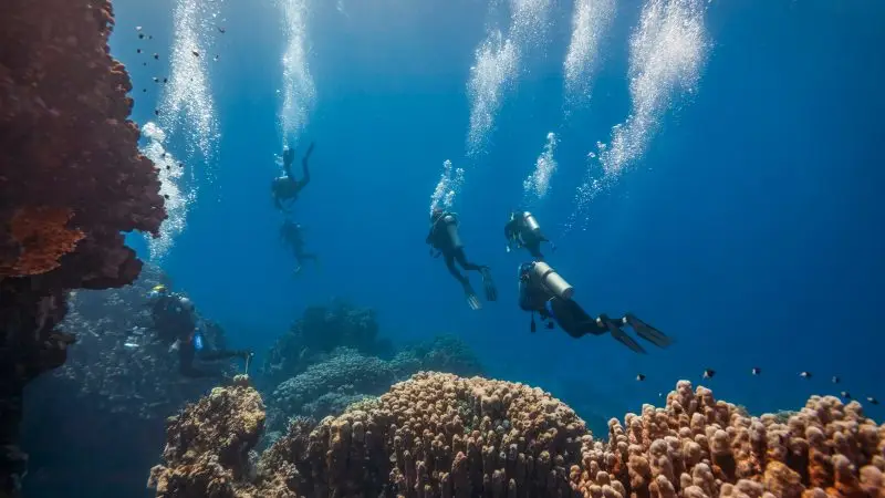 Group of scuba divers with different air consumption rates